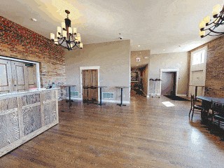 Interior of the 1894 Restoration Building &mdash; exposed brick, chandeliers, hardwood floors